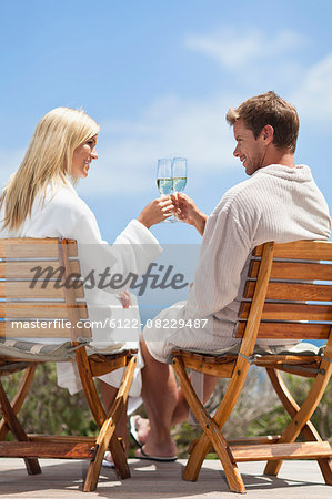 Couple toasting each other outdoors