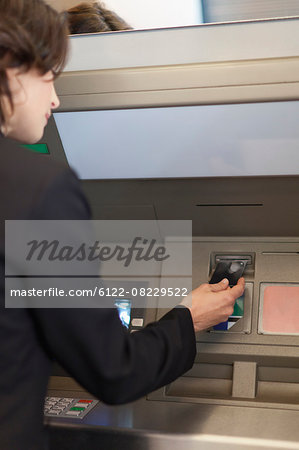 Businesswoman using ATM outdoors