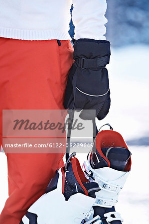 Person carrying ski boots in snow
