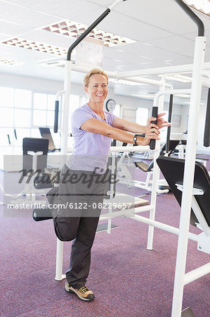 Woman using weights machine in gym