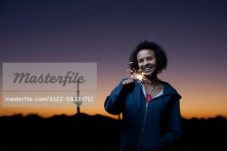 Woman playing with sparkler in desert