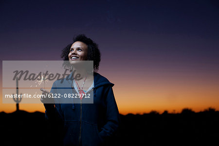 Woman playing with sparkler in desert