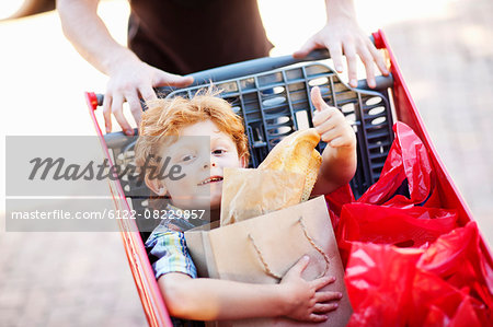 Boy riding in shopping cart