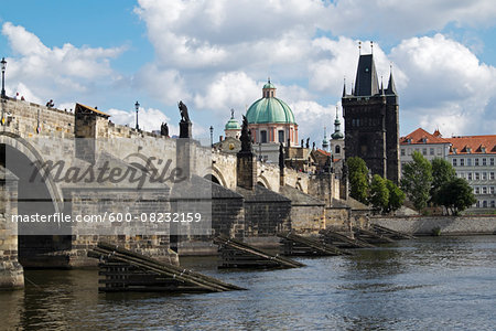 Charles Bridge crossing the Vltava River with the Old Town Bridge Tower and Church of St Francis Seraphinus, Prague, Czech Republic.