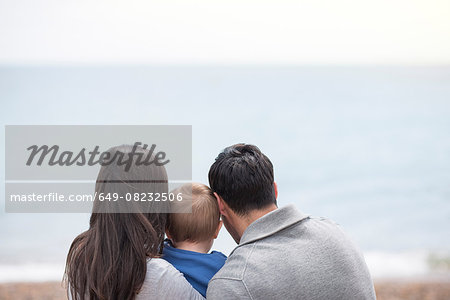 Young family looking at sea view, rear view