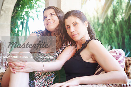 Portrait of mature woman and teenage daughter on patio