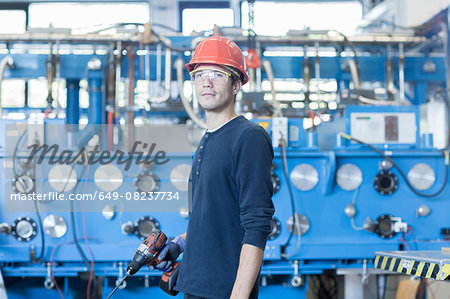 Portrait of factory engineer and industrial machinery