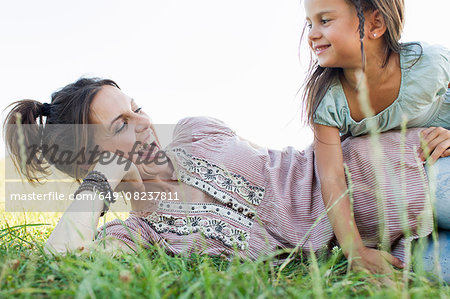 Mature woman and daughter laughing and playing in park