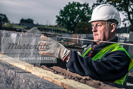 Workers laying bricks on construction site