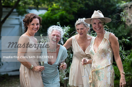 Elegant mature women enjoying champagne in urban garden