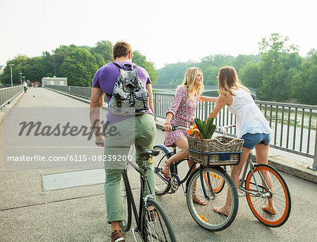 Group of friends with bicycles on city bridge