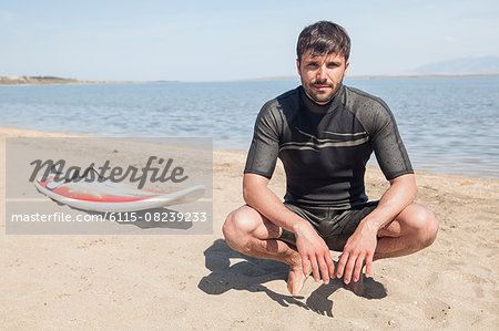 Surfer sitting on beach