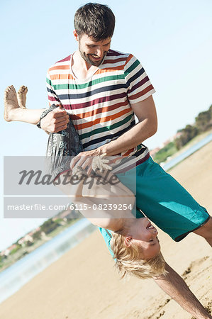 Father on beach fooling around with son