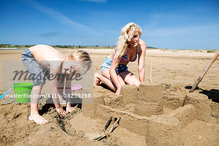 Mother and son making sandcastle on beach