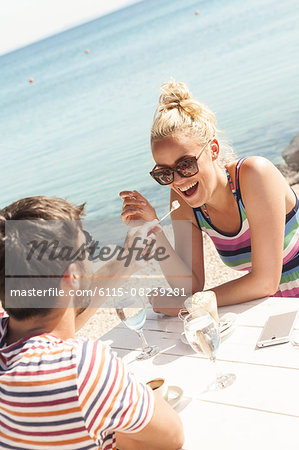 Young couple sitting at table in beach bar