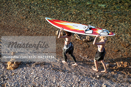 Female surfers carrying surfboard