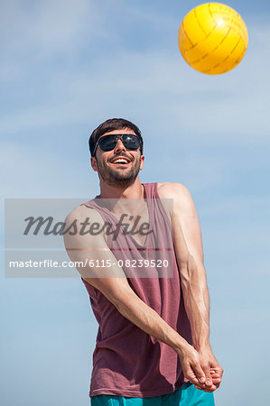 Young man playing beach volleyball