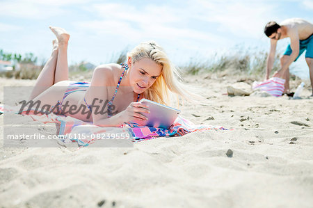 Young couple using digital tablet on beach