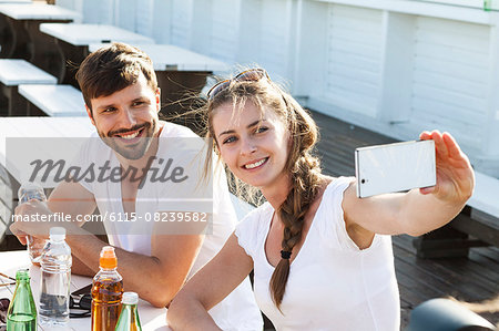 Young couple taking a self portrait in beach bar