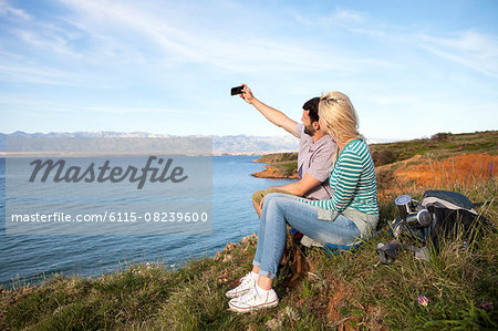 Young couple taking self portrait on cliff