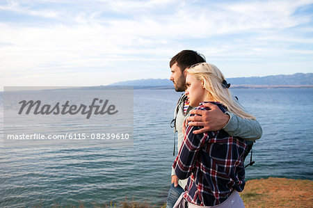 Young couple on cliff looking at sea