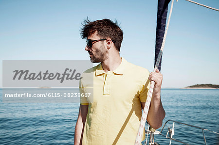 Young man overlooking sea on sailboat, Adriatic Sea