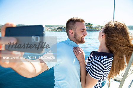 Young couple photographing themselves on sailboat, Adriatic Sea