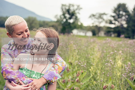 A mature woman and a young girl in a wildflower meadow.