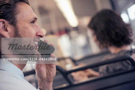 A man on a city bus, talking on his cell phone