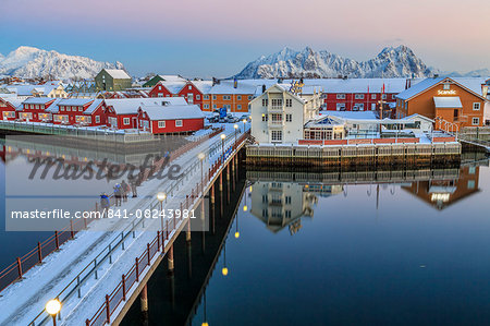 Hikers admire sunset colors on the typical red houses from a deck, Svolvaer, Lofoten Islands, Arctic, Norway, Scandinavia, Europe