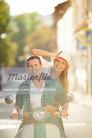 Smiling couple on a scooter outdoors