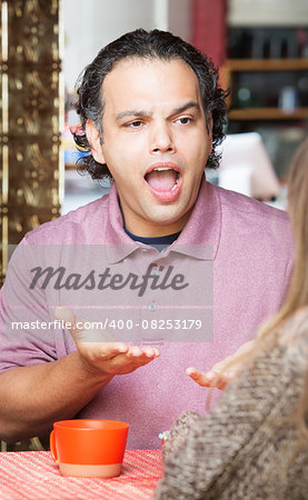Frustrated man with woman at coffee house indoors