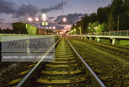 Passenger platforms and freight train on the early morning station.