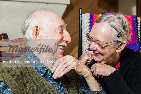 Happy Caucasian elderly couple sitting indoors smiling