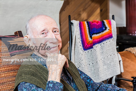 Older gentleman smiling and seated in his living-room
