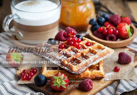 Belgian waffles with fresh berries and cappuccino coffee for breakfast, selective focus