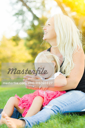 Pretty Mother and Little Girl Having Fun Together in the Grass.