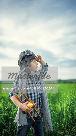 Little boy with airplane in the field