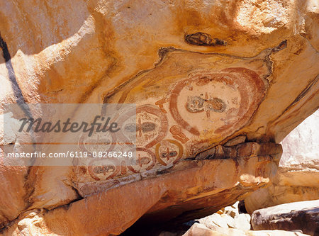 Group of Wandjana 'faces' on shaded underside of rock, near King Edward River, Kulumburu Road, Kimberley, Western Australia, Australia