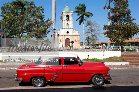 Classic red American car parked by the old square in Vinales village, Pinar del Rio, Cuba, West Indies, Central America