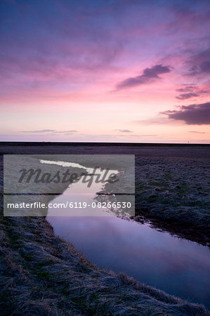Stream meandering into the distance and reflecting colours in the twilight sky, near Hella, South Iceland, Iceland, Polar Regions