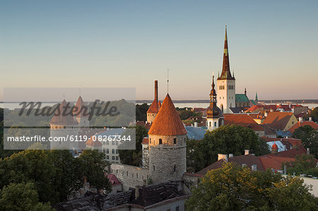 Medieval town walls and spire of St. Olavs church at dusk, Tallinn, Estonia, Baltic States, Europe