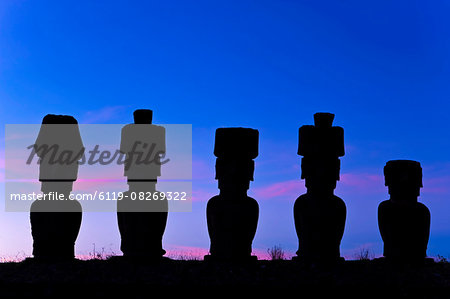 Anakena beach, monolithic giant stone Moai statues of Ahu Nau Nau, four of which have topknots, silhouetted at dusk, Rapa Nui (Easter Island), UNESCO World Heritage Site, Chile, South America Anakena beach, monolithic giant stone Moai statues of Ahu Nau Nau, four of which have topknots, silhouetted at dusk, Rapa Nui (Easter Island), UNESCO World Heritage Site, Chile, South America