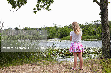 Rear of girl looking out over rural lake