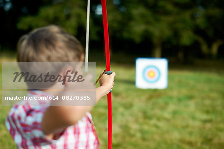 Rear view of teenage boy practicing archery