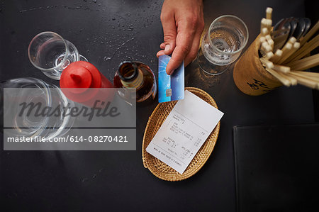 Overhead view of man paying with credit card