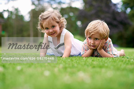 Surface level of boy and girl lying on grass