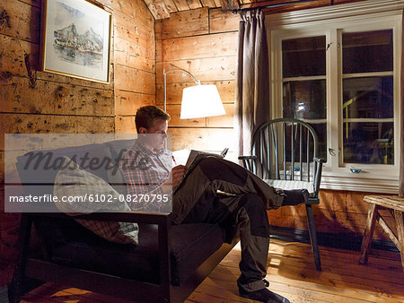 Young man reading book at night