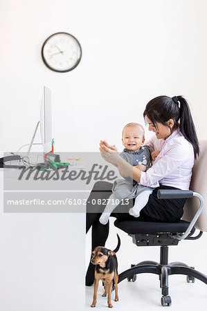 Businesswoman with baby girl in office Businesswoman with baby girl in office