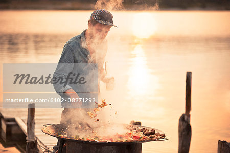 Man having barbecue at water